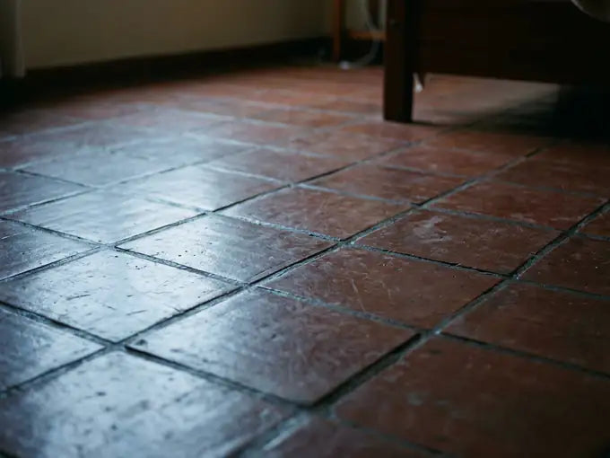 Piso de baldosa desnudo en un cuarto al amanecer, sin alfombra